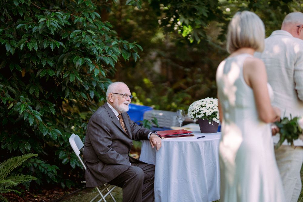 Garden party setting with blue tablecloths and lush greenery in background.