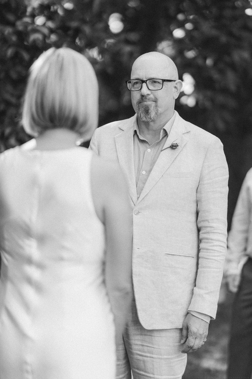 Black and white profile of couple sharing intimate moment during outdoor ceremony.