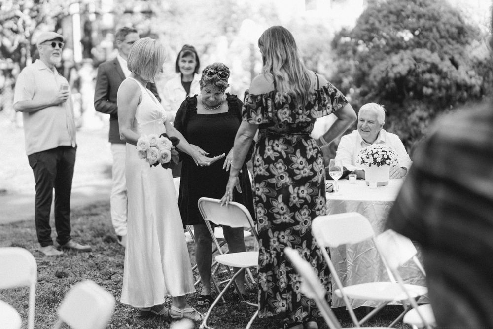 Black and white photo of guests mingling at an outdoor garden party.