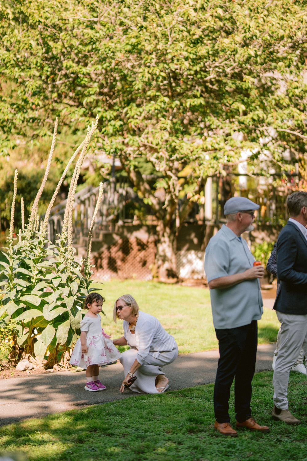 People gathered in a lush garden setting during an outdoor social event.