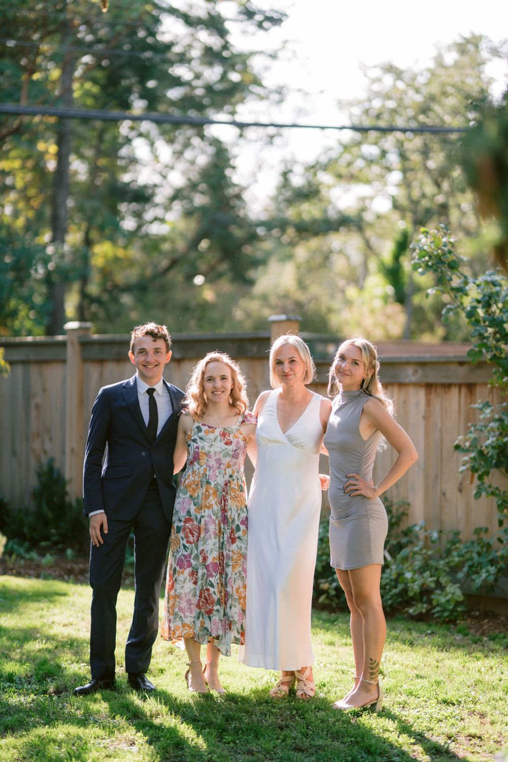 Wedding party poses together in a backyard garden setting.