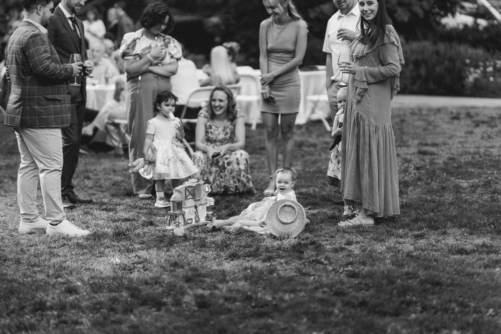 Vintage black and white photo of people gathered on grass at a social gathering.