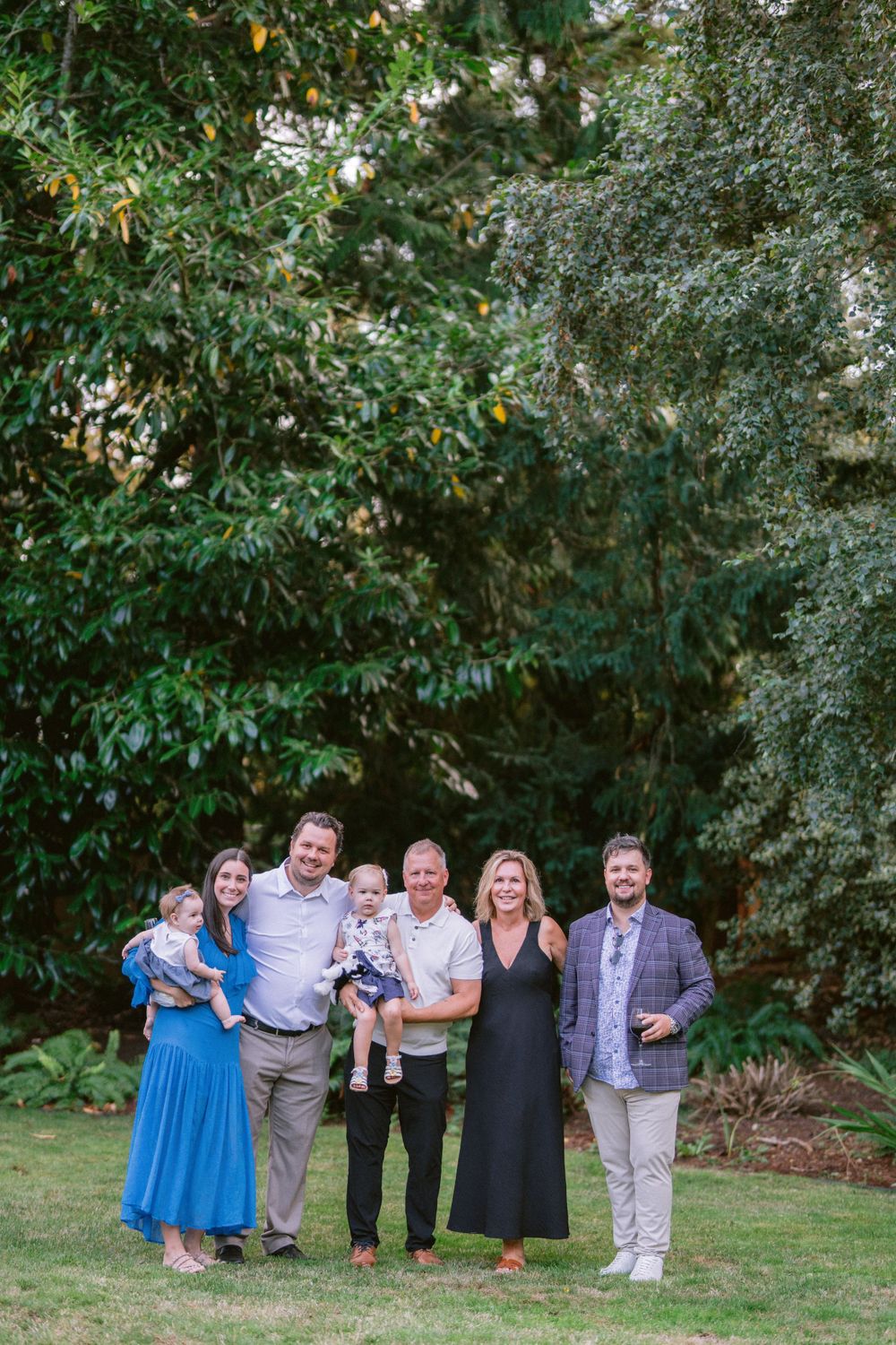 Small group portrait taken outdoors against lush green foliage background.