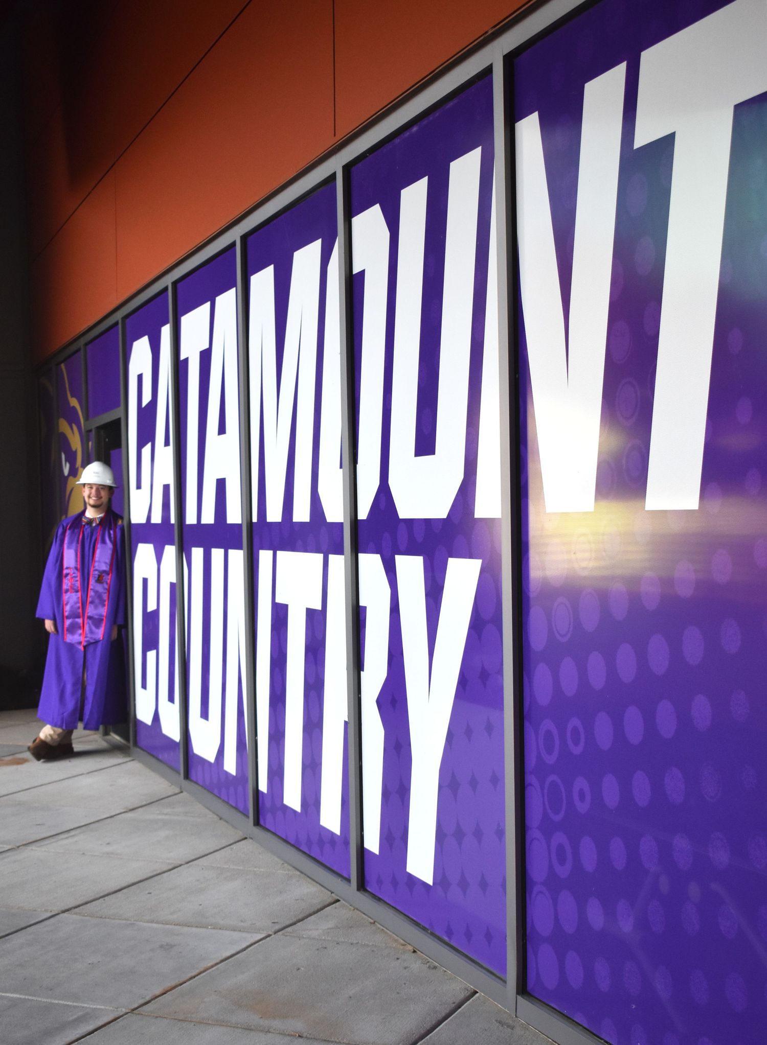 Purple wall display showing 'Catamount Country' text with a university mascot figure standing beside it.