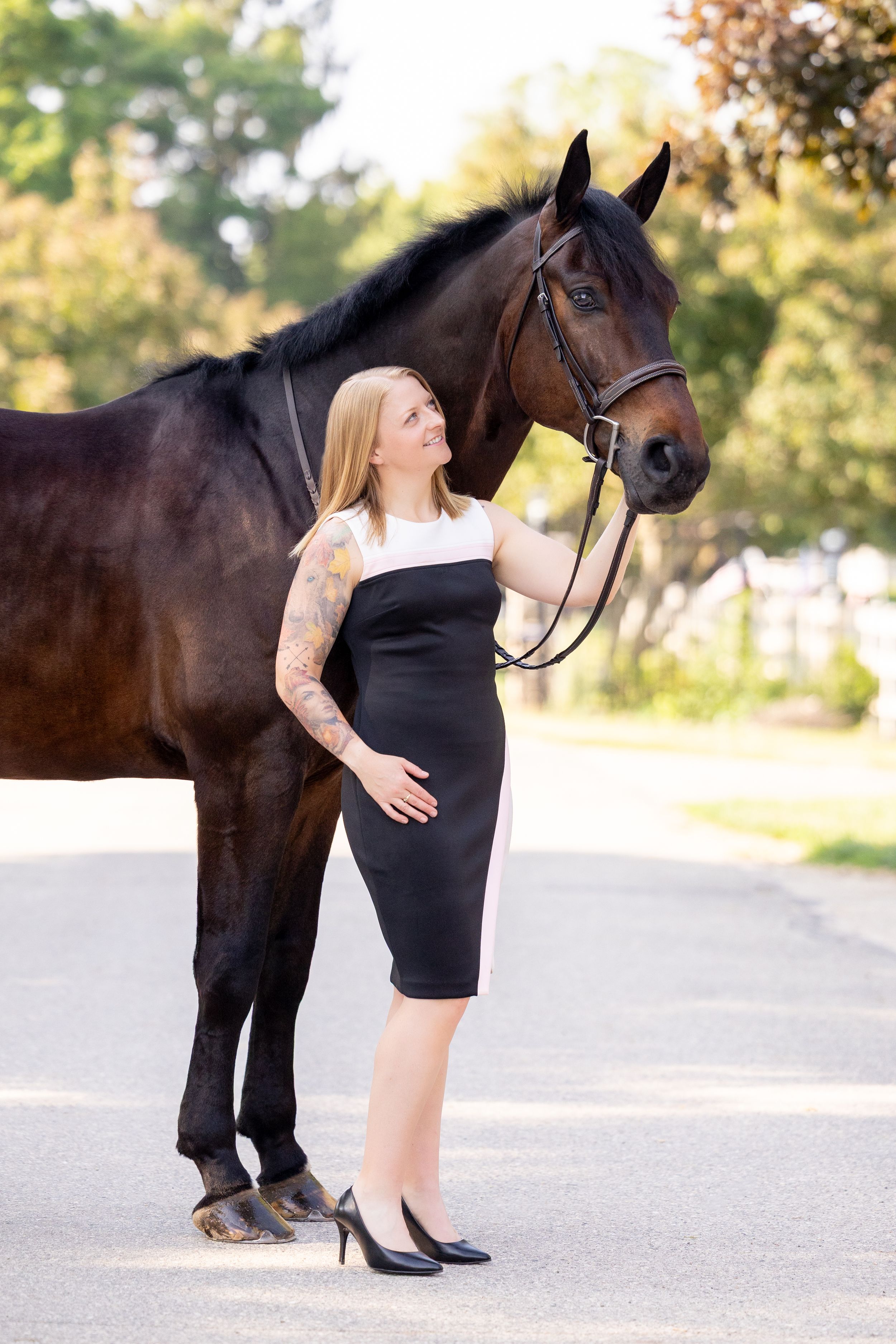 girl in cocktail dress with large bay horse