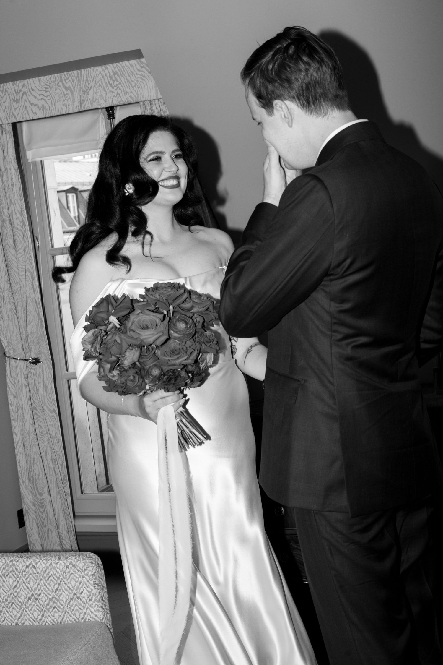A couple in wedding attire shares a romantic dance moment on an elegant stone porch with ornate railings.