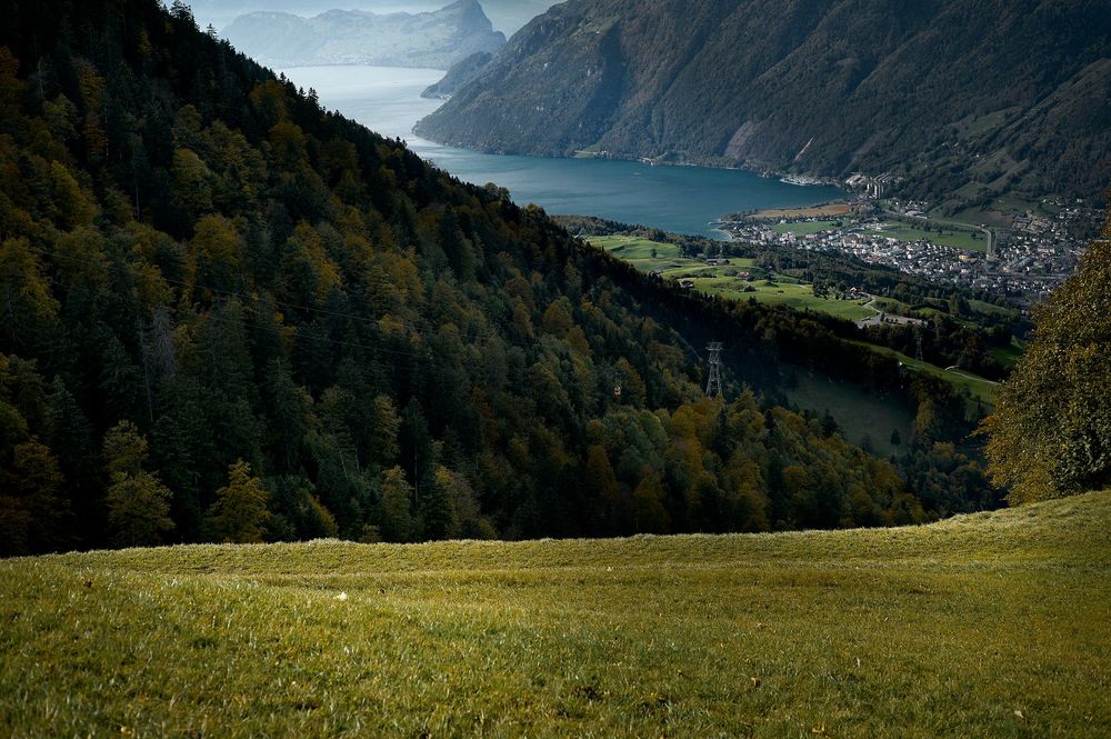Scenic mountain landscape with green meadows and distant alpine valley views under cloudy skies in Austria.