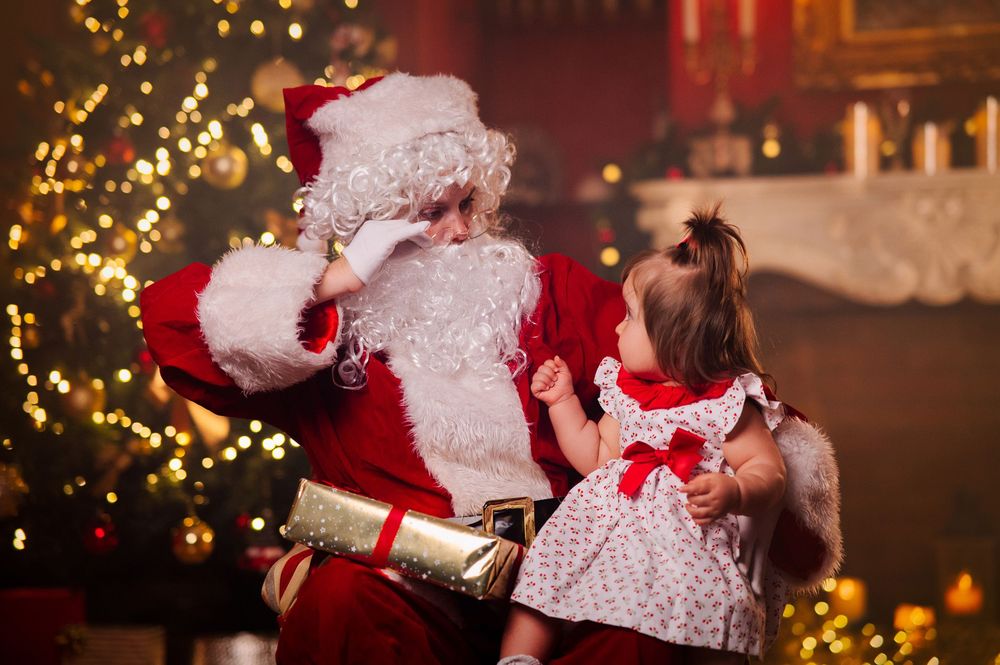 Fotografía de navidad Santa con una niña mirandole atentamente