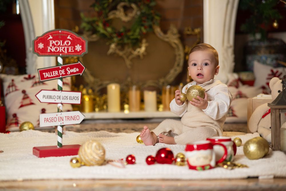 A festive Christmas display with decorative signs, ornaments, and holiday decor arranged on a wooden surface.
