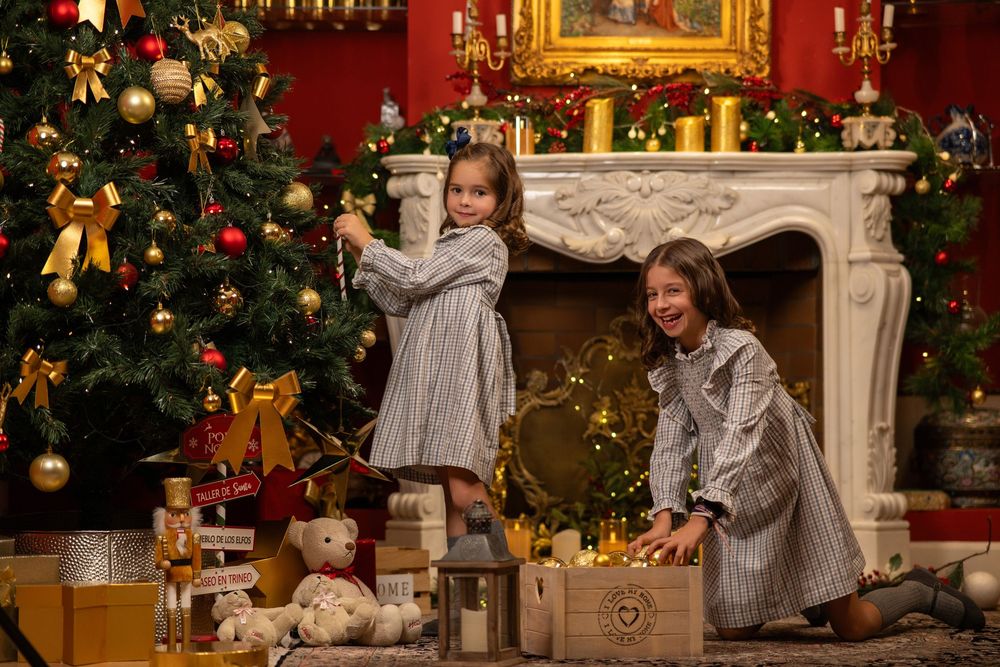 Una escena navideña festiva con árboles decorados, calcetines y una acogedora chimenea en una elegante habitación con paredes rojas.