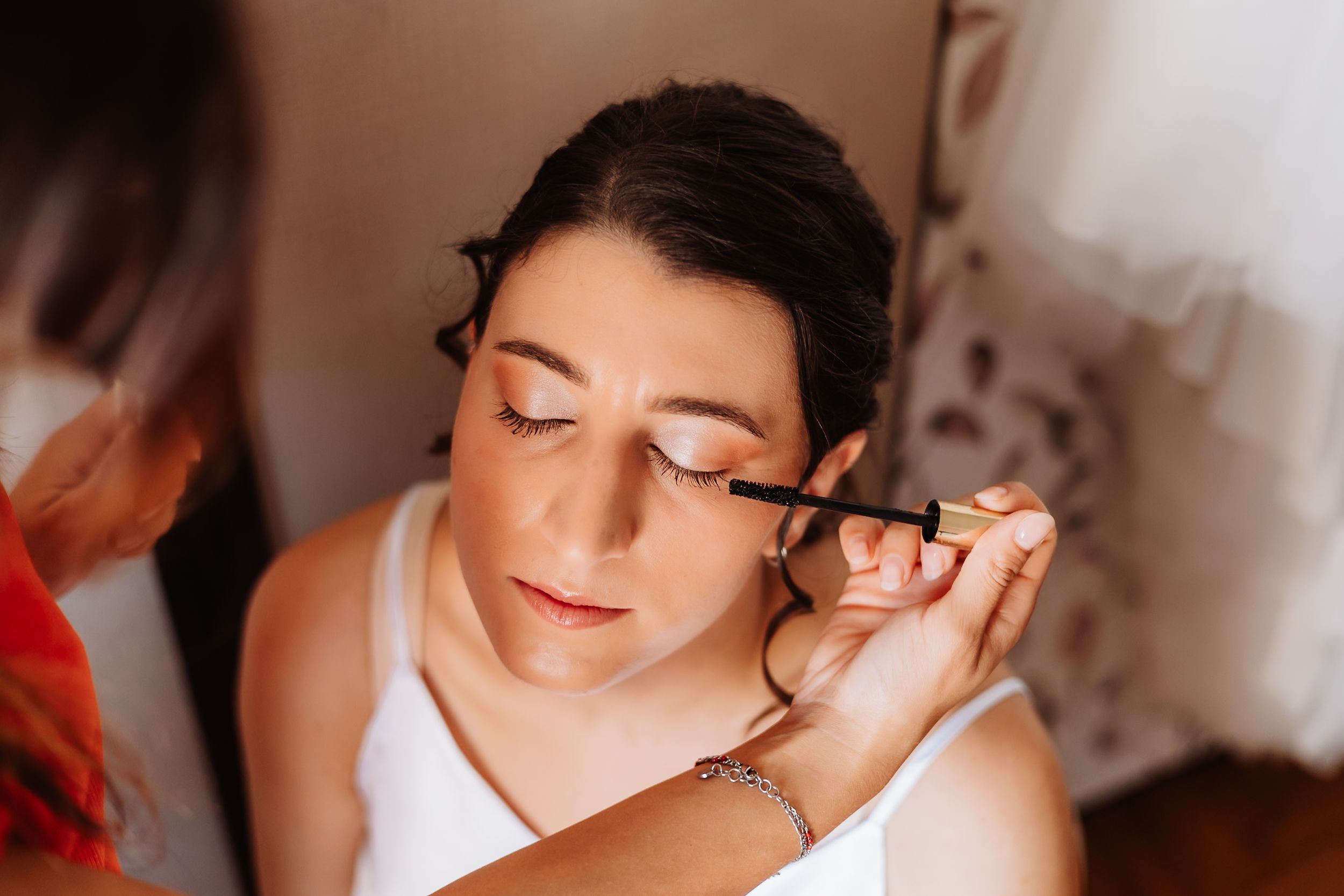 Close-up shot of bridal hair styling showing soft curls being arranged.