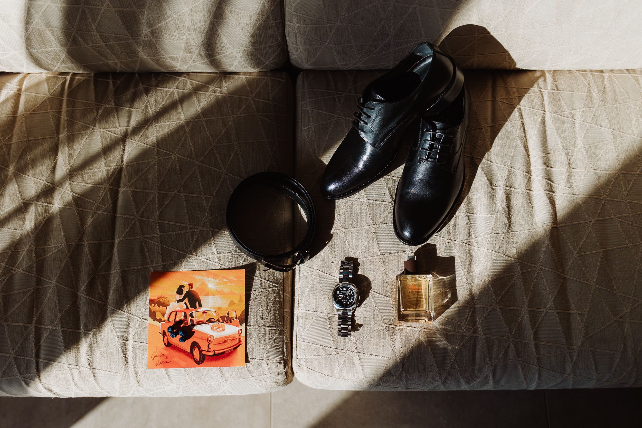 Black leather dress shoes being polished and shined on a light surface with dramatic shadows.
