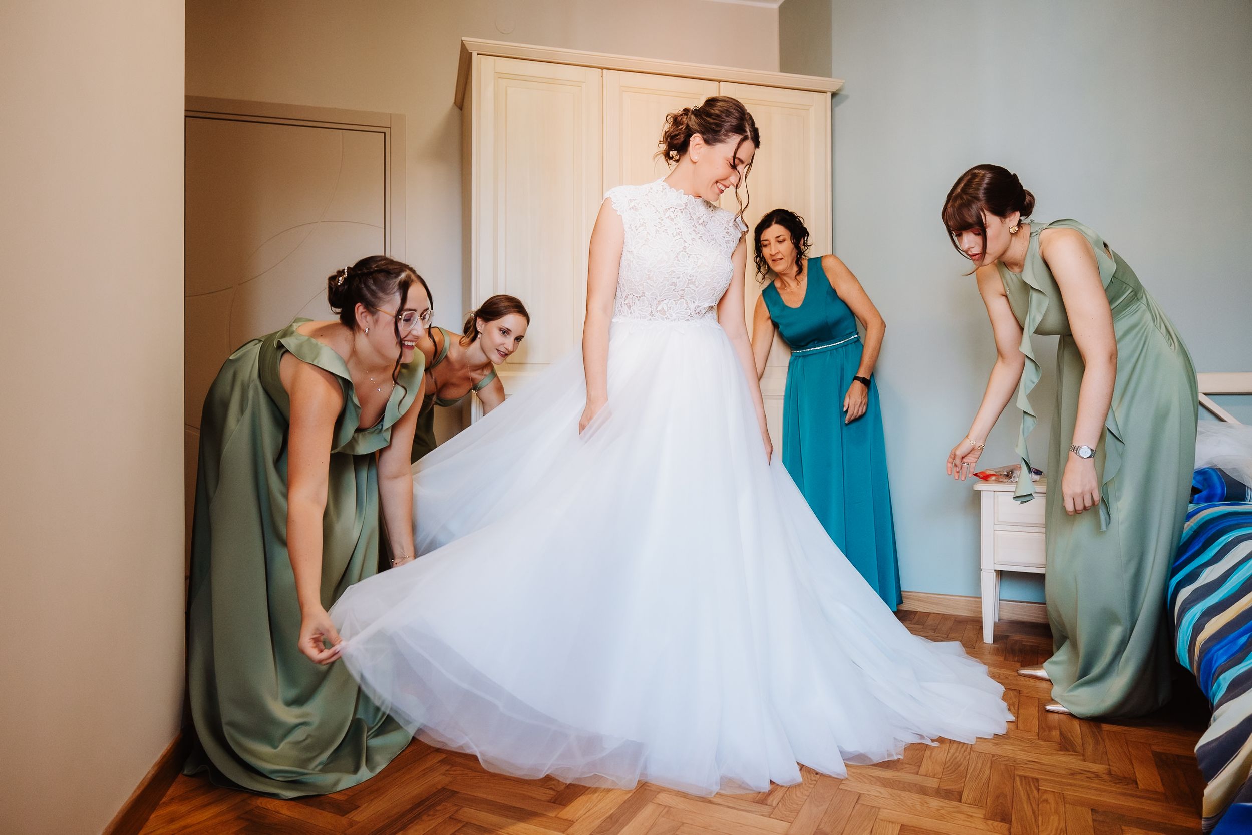 A series of photos showing bridesmaids helping a bride get ready in her white tulle wedding gown.