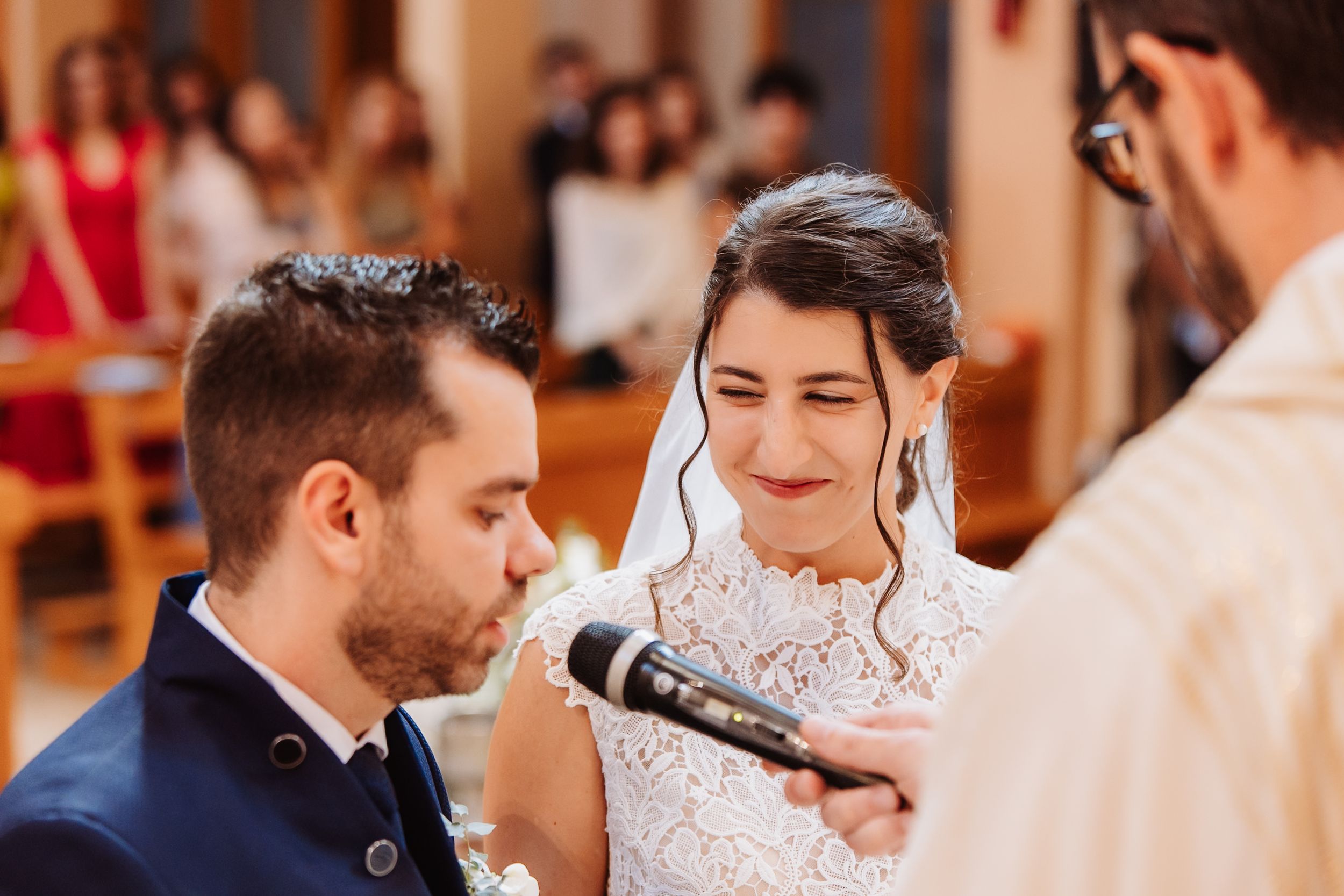 Wedding guests share joyful moments and laughter during an indoor reception celebration.