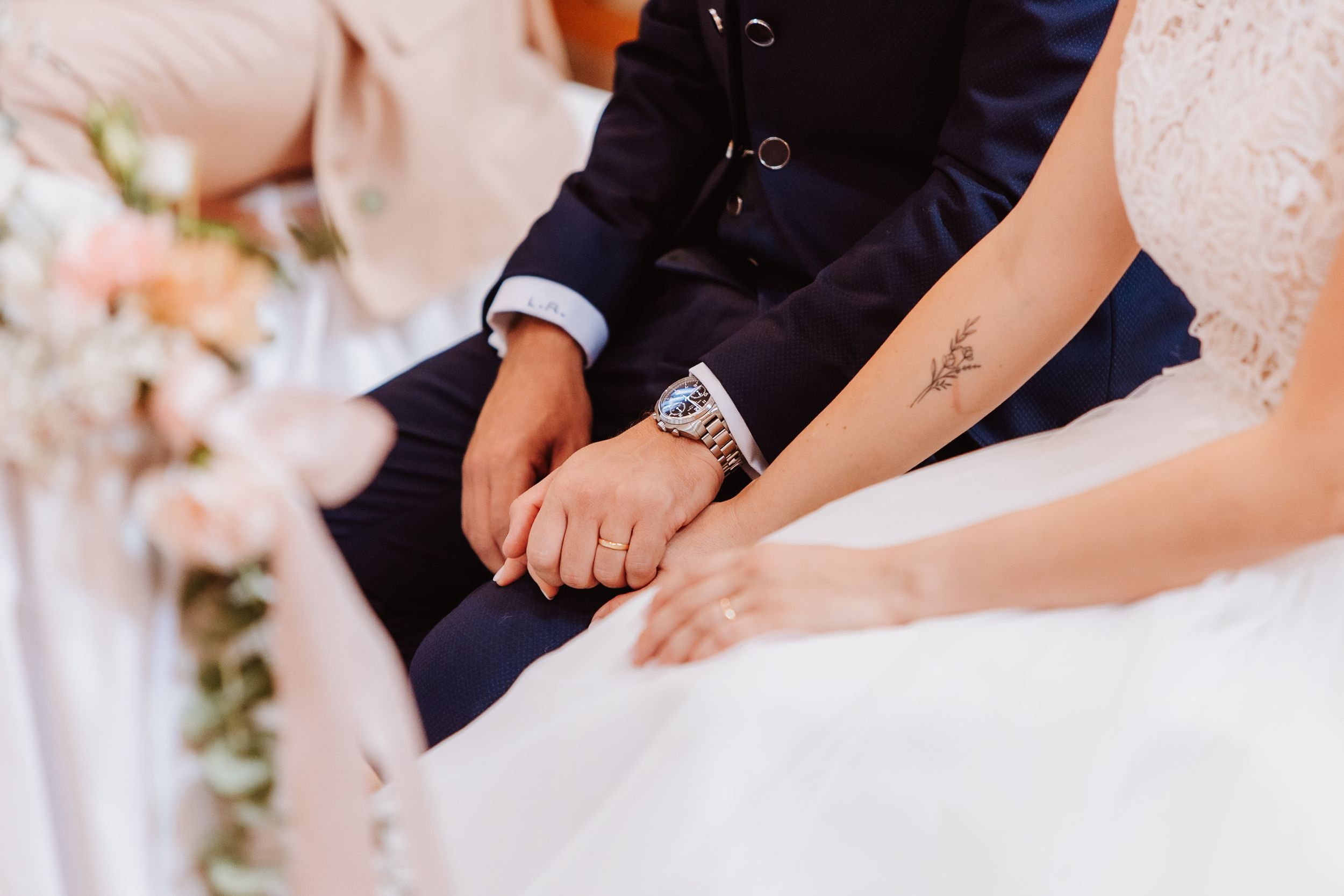 Close-up view of wedding rings being exchanged during an intimate ceremony.