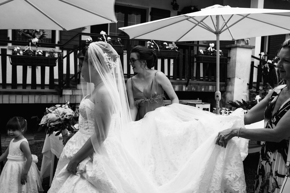 A black and white wedding photograph showing a bride in a flowing white dress dancing at an outdoor reception.