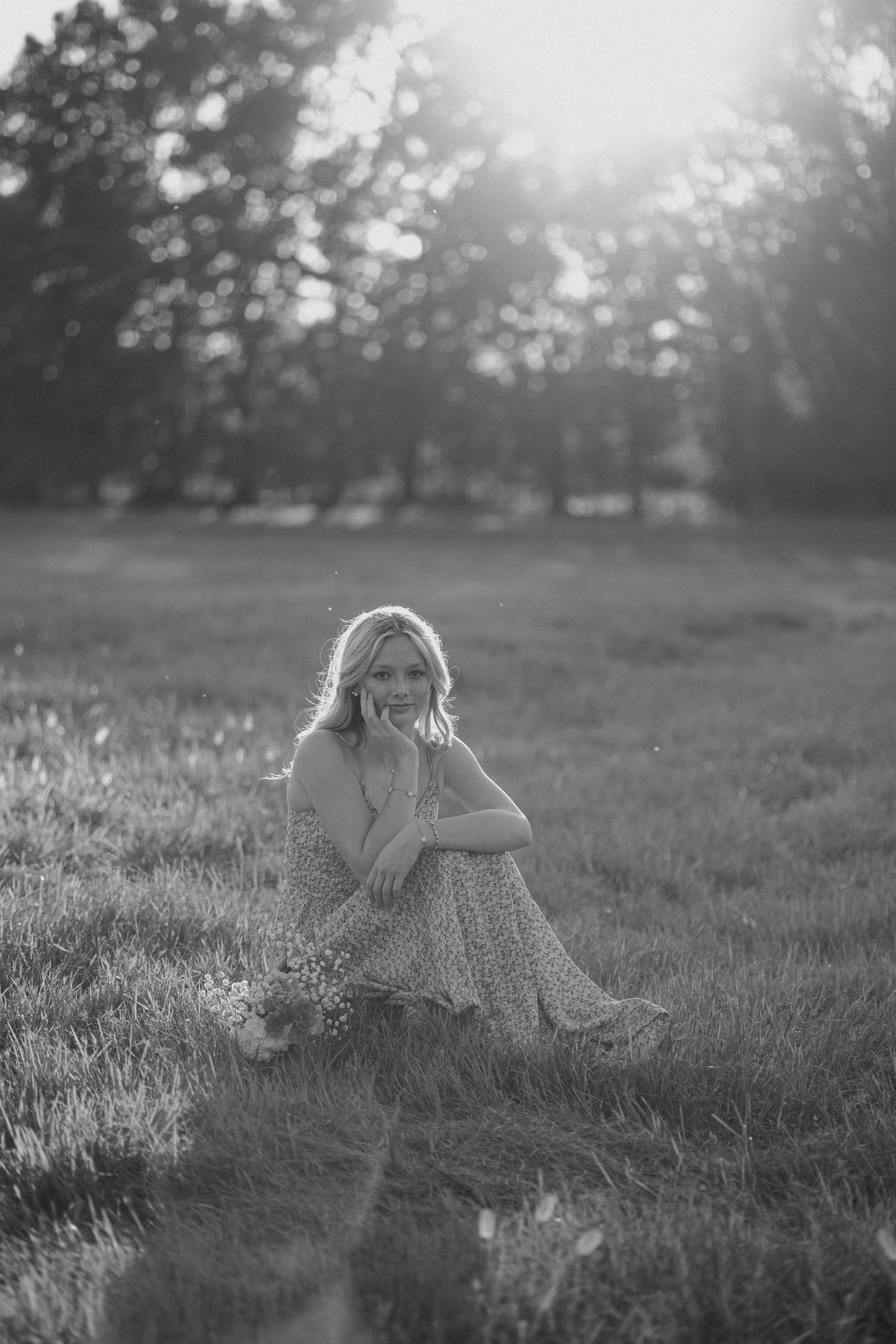 Dreamy black and white portraits of someone sitting in a misty field.