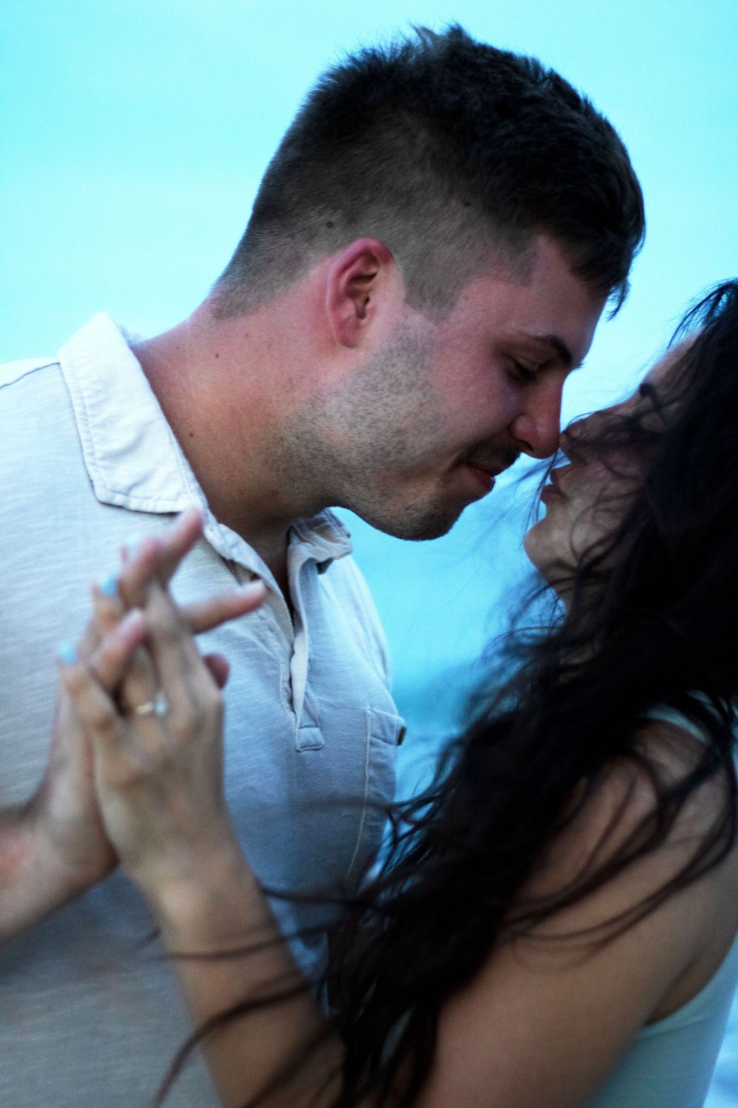 Romantic couple sharing intimate kisses in a series of blue-tinted photos.