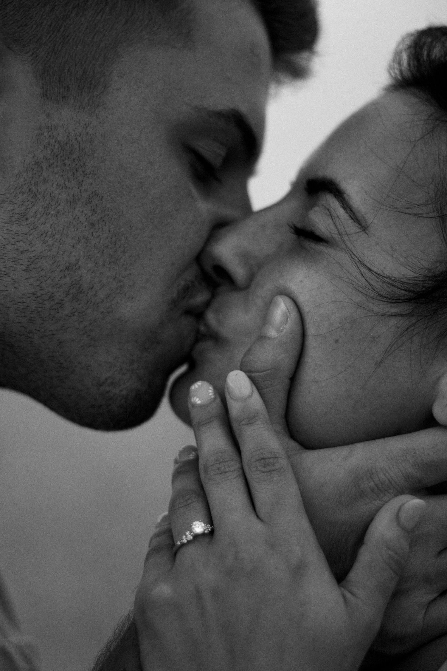 Close-up black and white shots of a tender kiss between a couple.