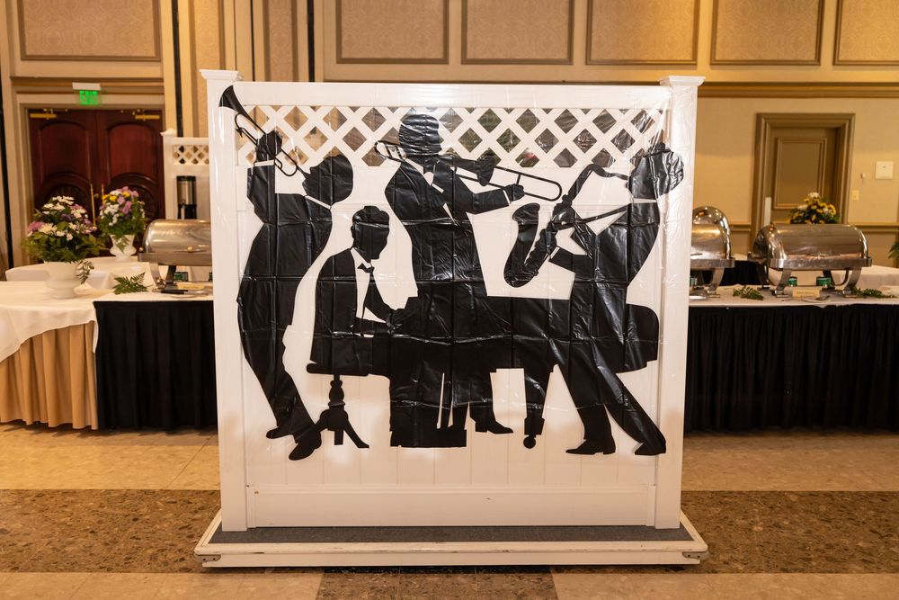 Musicians in formal attire perform at an elegant event in a luxurious ballroom setting.