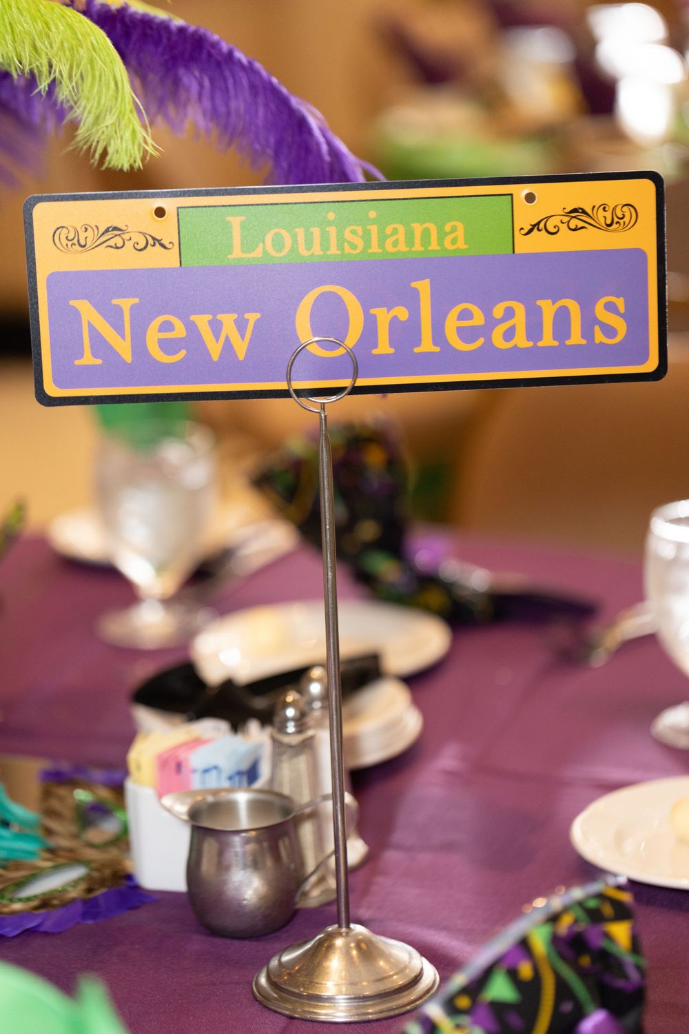 Decorative table signs reading Louisiana and New Orleans with purple and green Mardi Gras themed decor.
