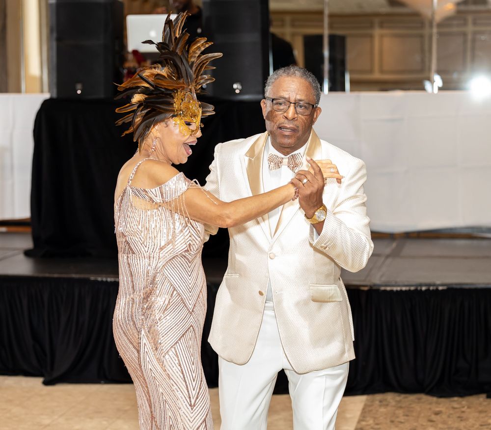 Couple sharing a dance moment in formal attire at an indoor venue.