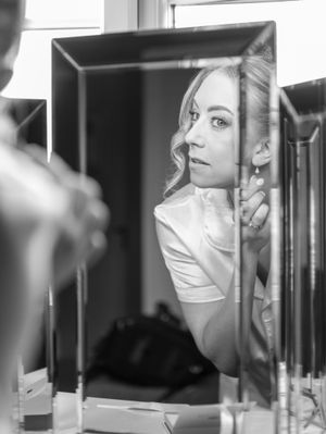 A black and white artistic photo sequence showing a person wearing a medical mask looking through a window or mirror.