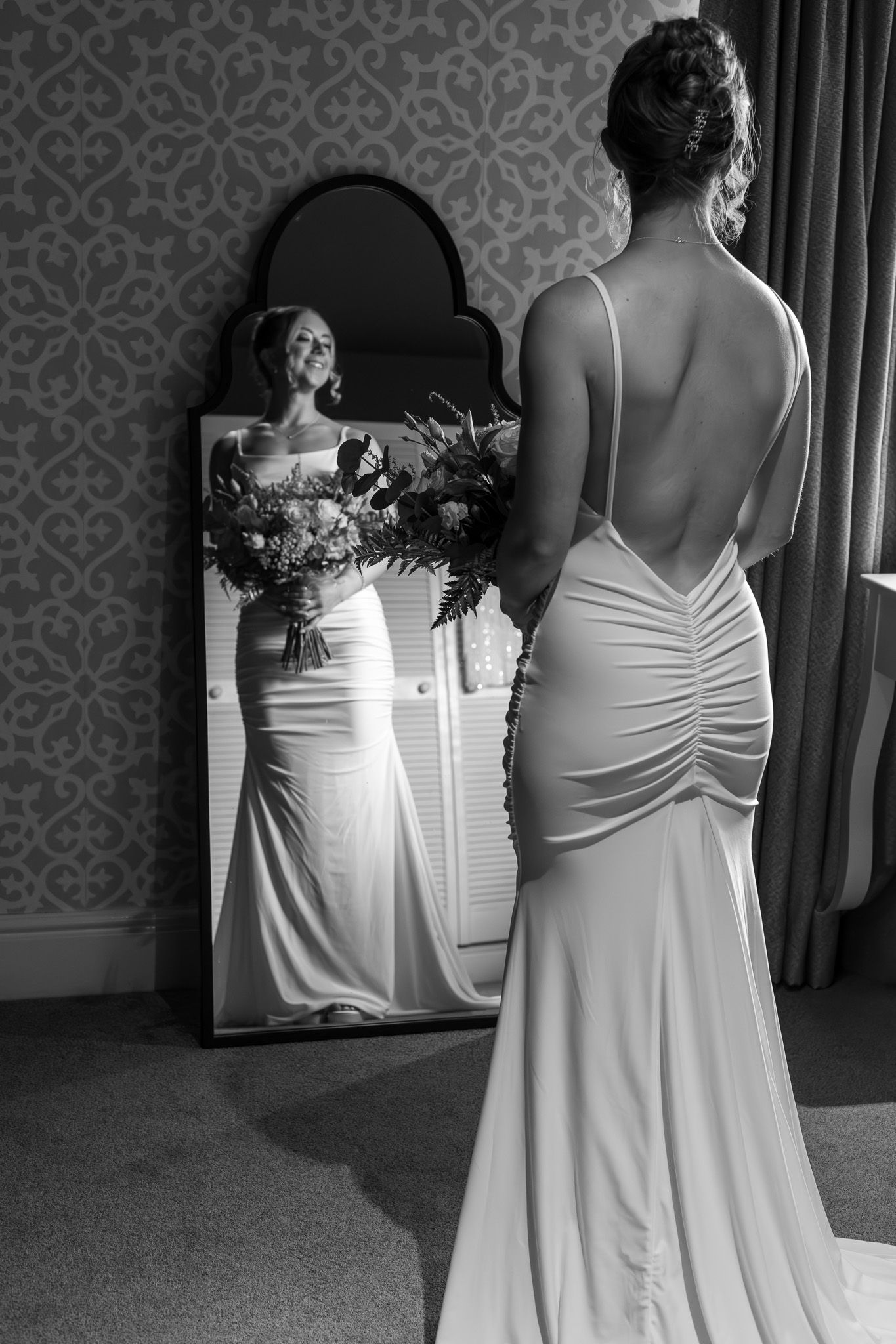 Black and white photo sequence showing back view of two people in white formal dresses standing in an elegant room.