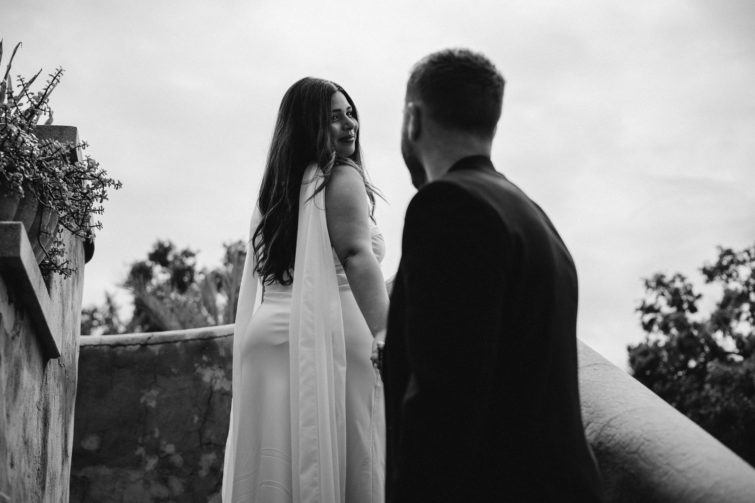 A black and white wedding photo montage showing intimate moments between a bride and groom in an outdoor setting.