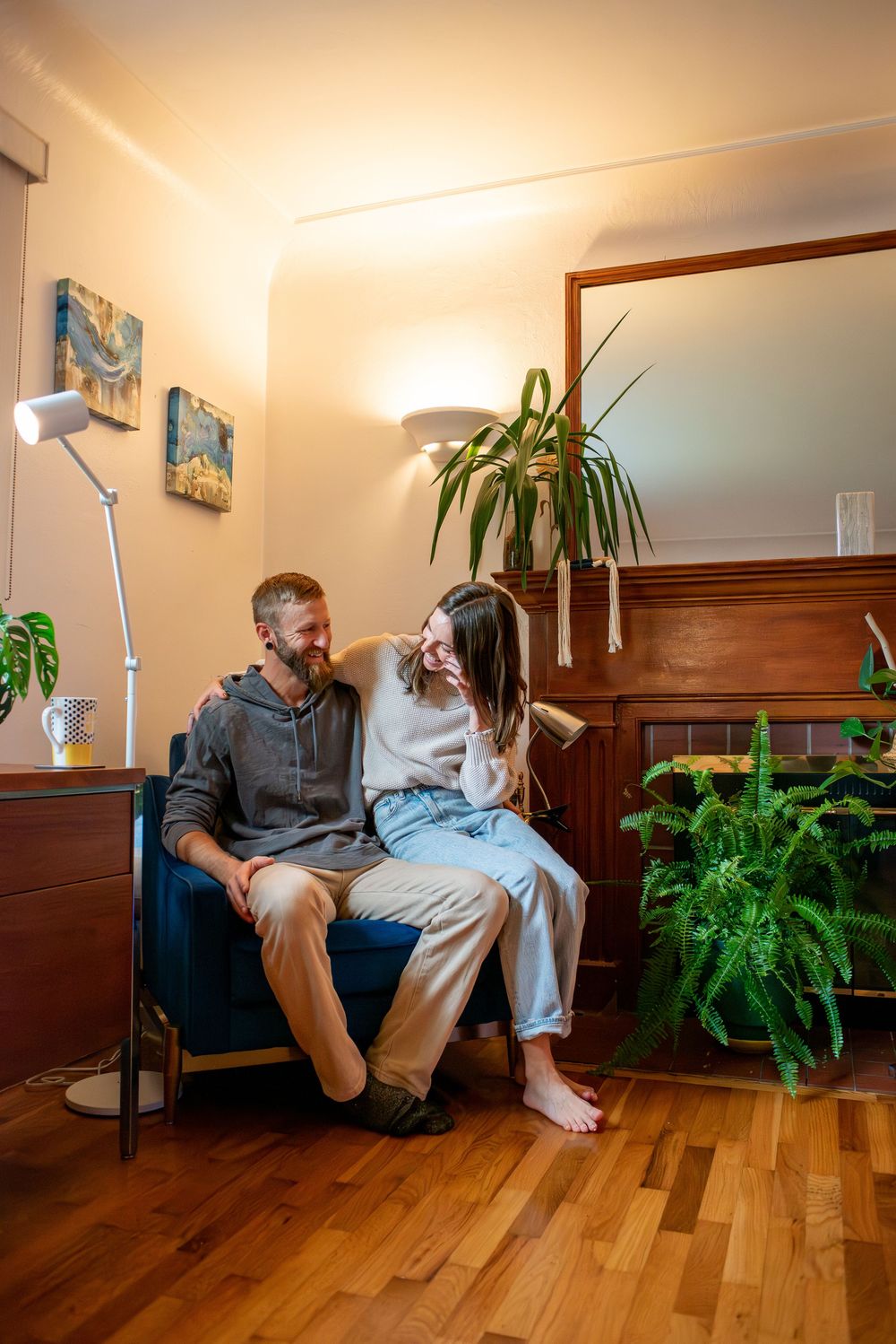 A couple sitting together in a chair in their home, laughing in Lansing, Michigan