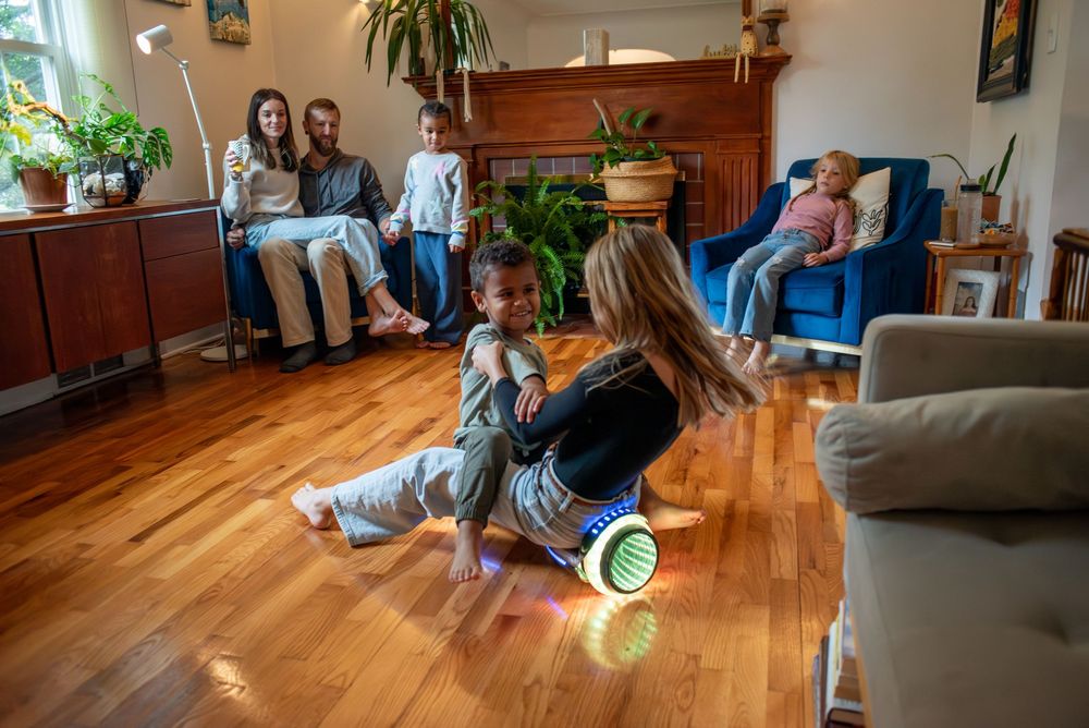 Two children spinning on a hoverboard in their family living room in Lansing, Michigan