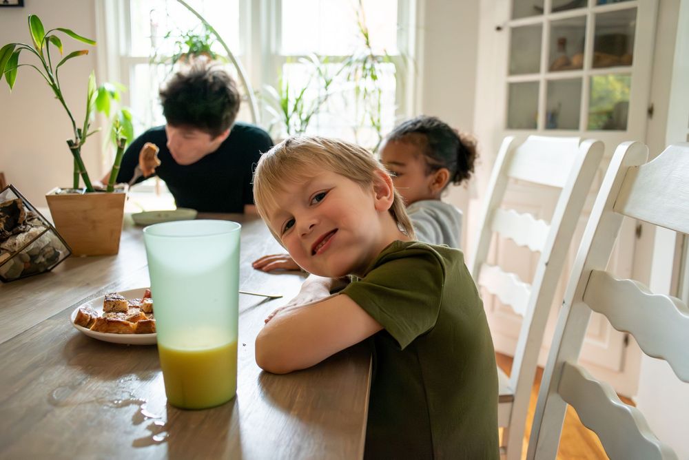 A child eating breakfast at their family dining table and smiling at home in Lansing, Michigan