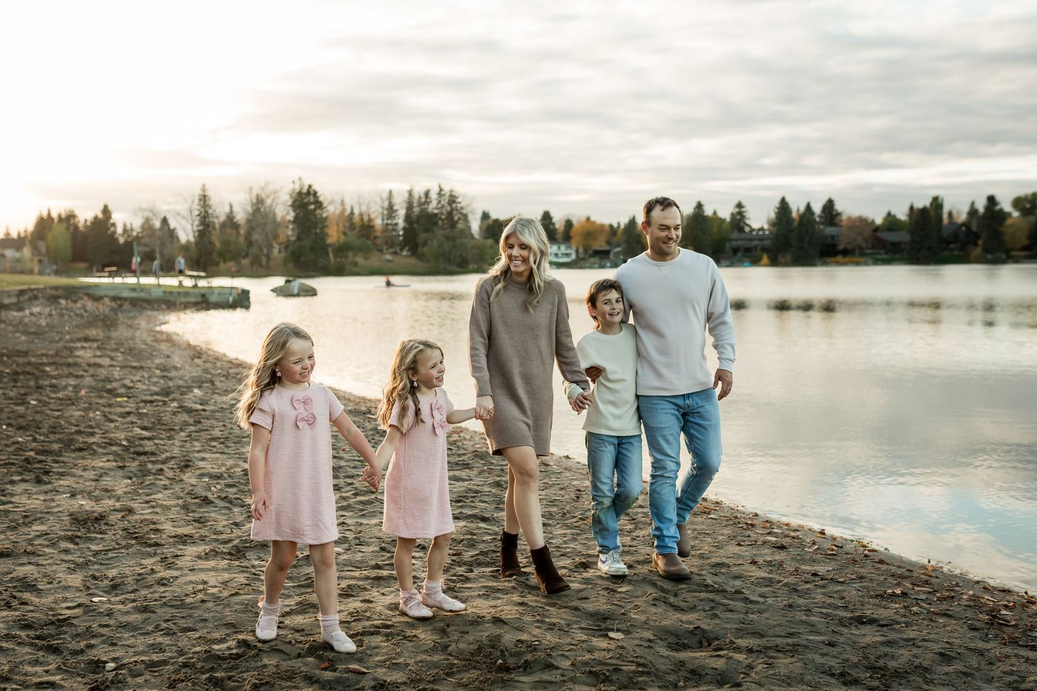 Family laughing and walking on the beac in fall at a family photography session in Calgary