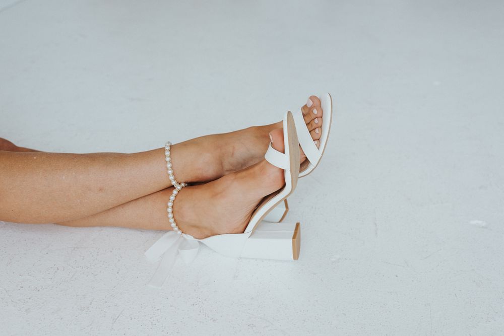 Close-up shots of delicate white heels and jewelry details.