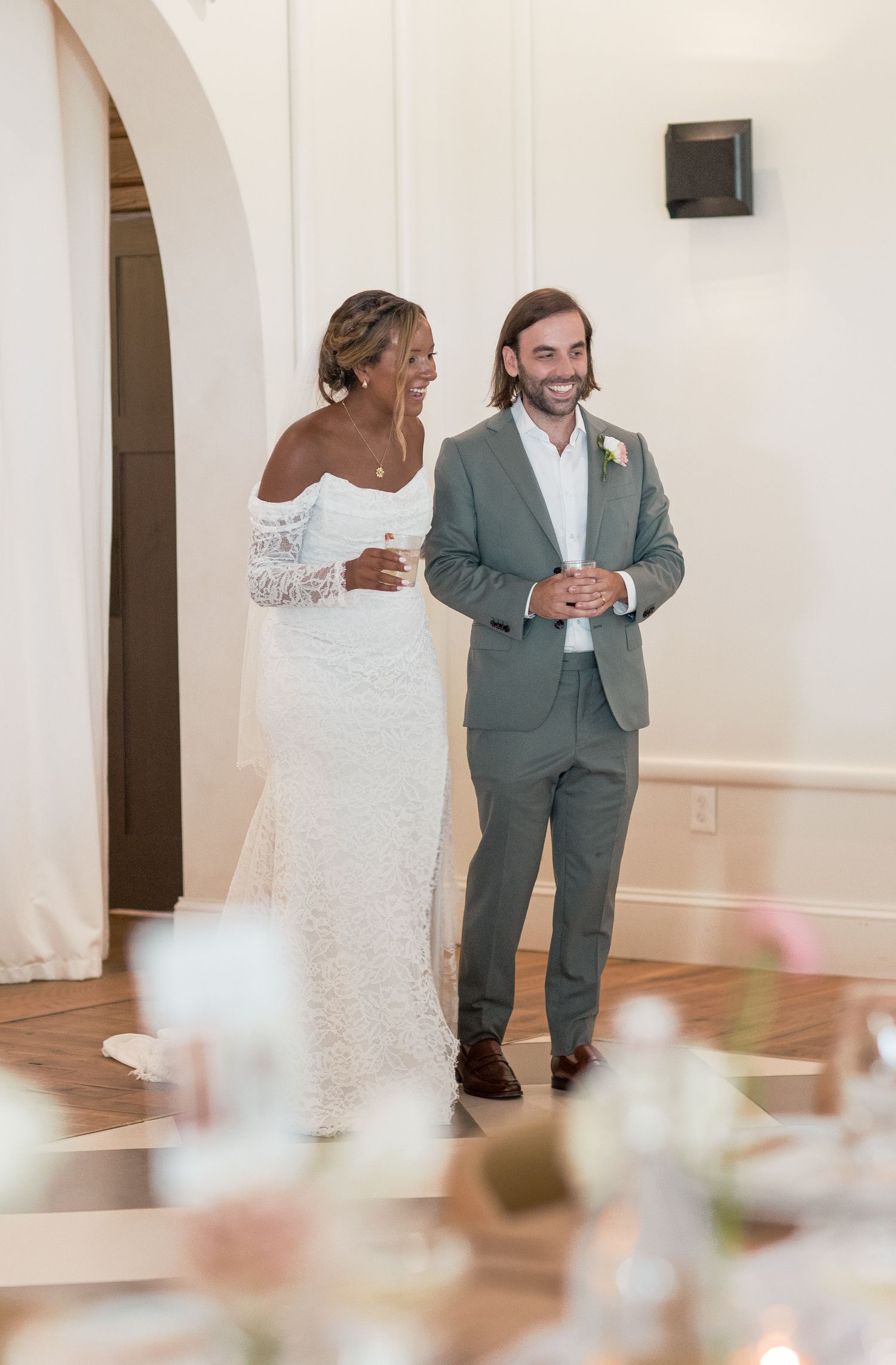 Wedding couple dancing and twirling in a bright white ballroom space.