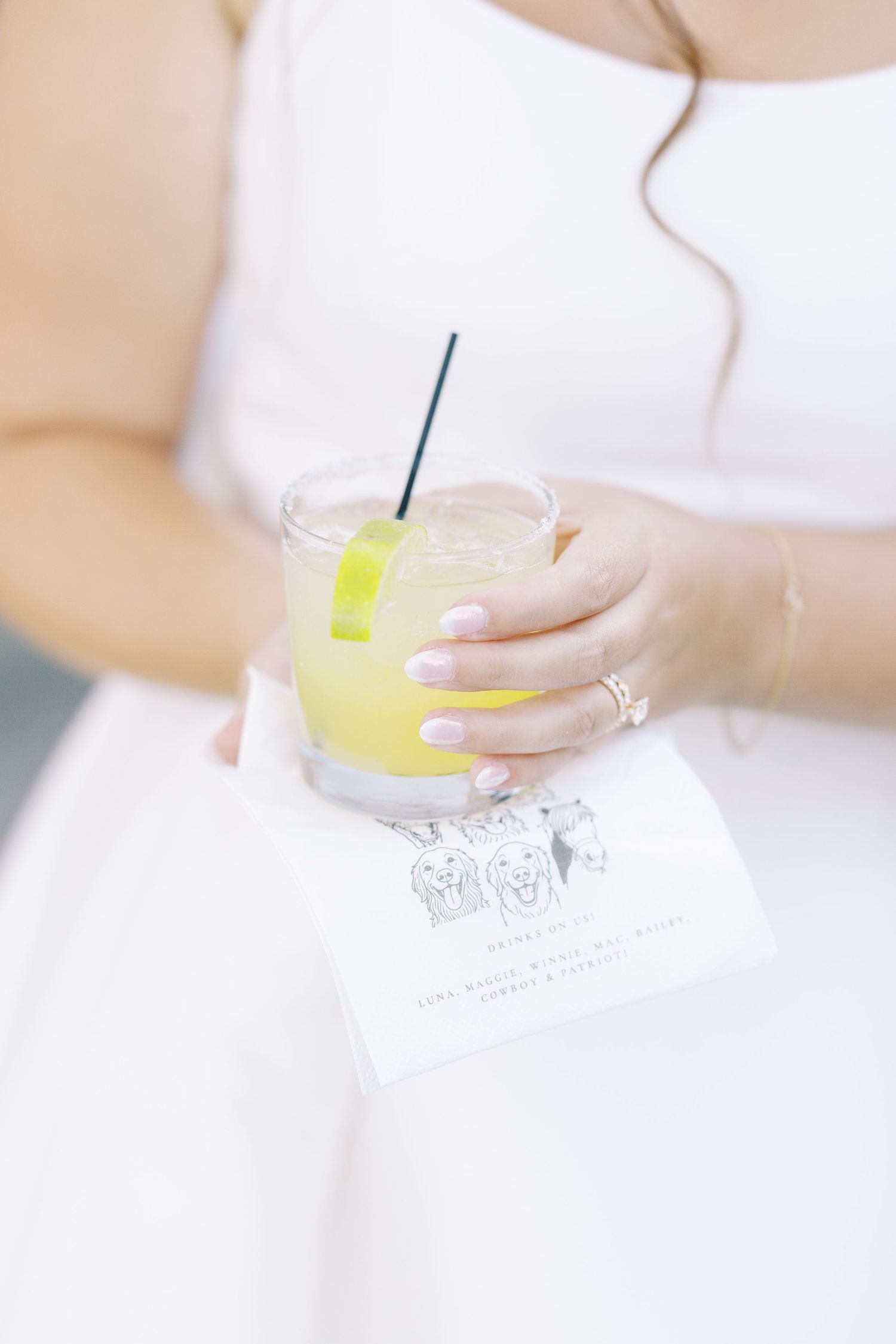 A refreshing yellow cocktail served in a clear glass with straw on white background.