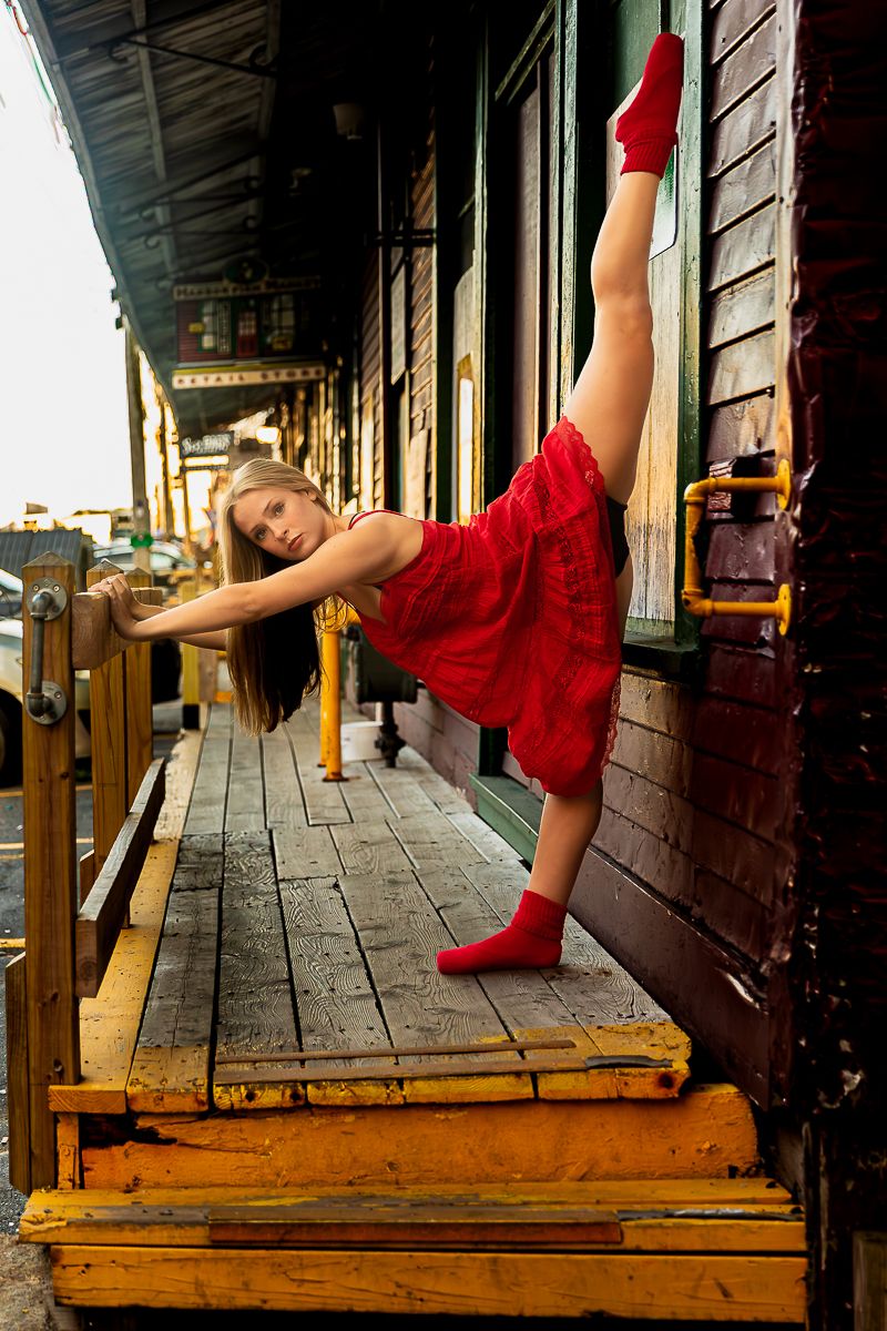 Dance sequence showing graceful movements and red dress against rustic wooden porch backdrop.