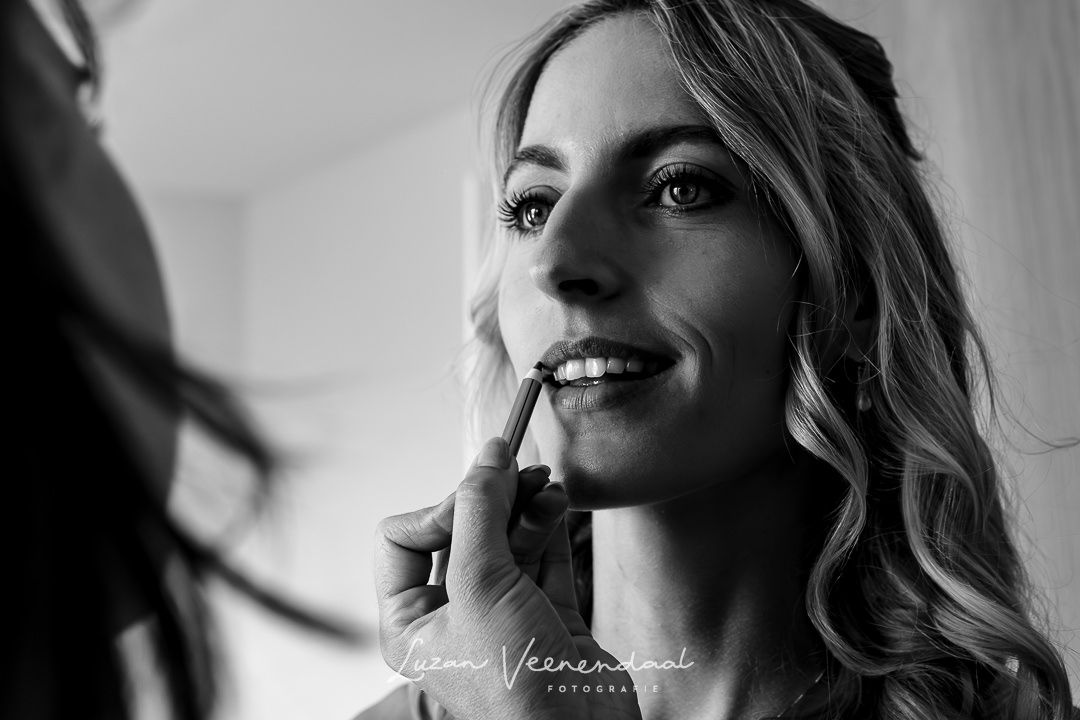 De finishing touch, de lipgloss op de lippen aanbrengen en dan is de bruid bijna klaar om in har bruidsjurk te stappen