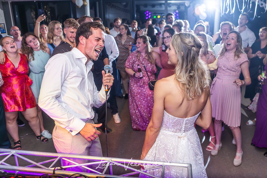 De bruidegom gaat tijdens de feestavond nog even een liedje zingen voor zijn bruid. Alle gasten genieten en zingen mee