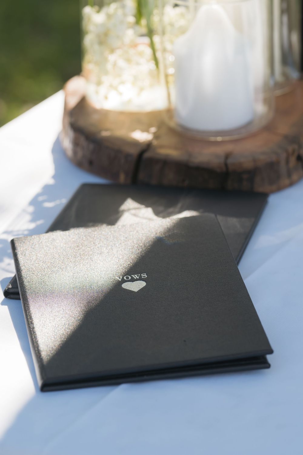 Several black graduation diplomas or certificates arranged on a rustic wooden table in natural lighting.