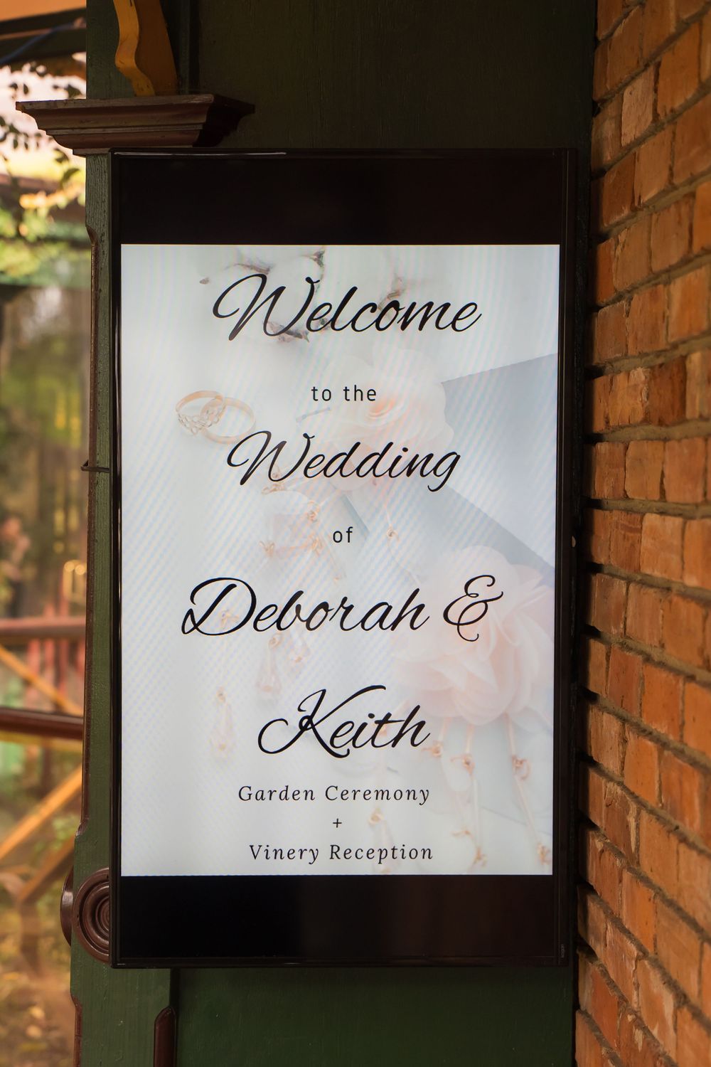 Four elegant wedding welcome signs with script lettering mounted on brick walls display reception details.