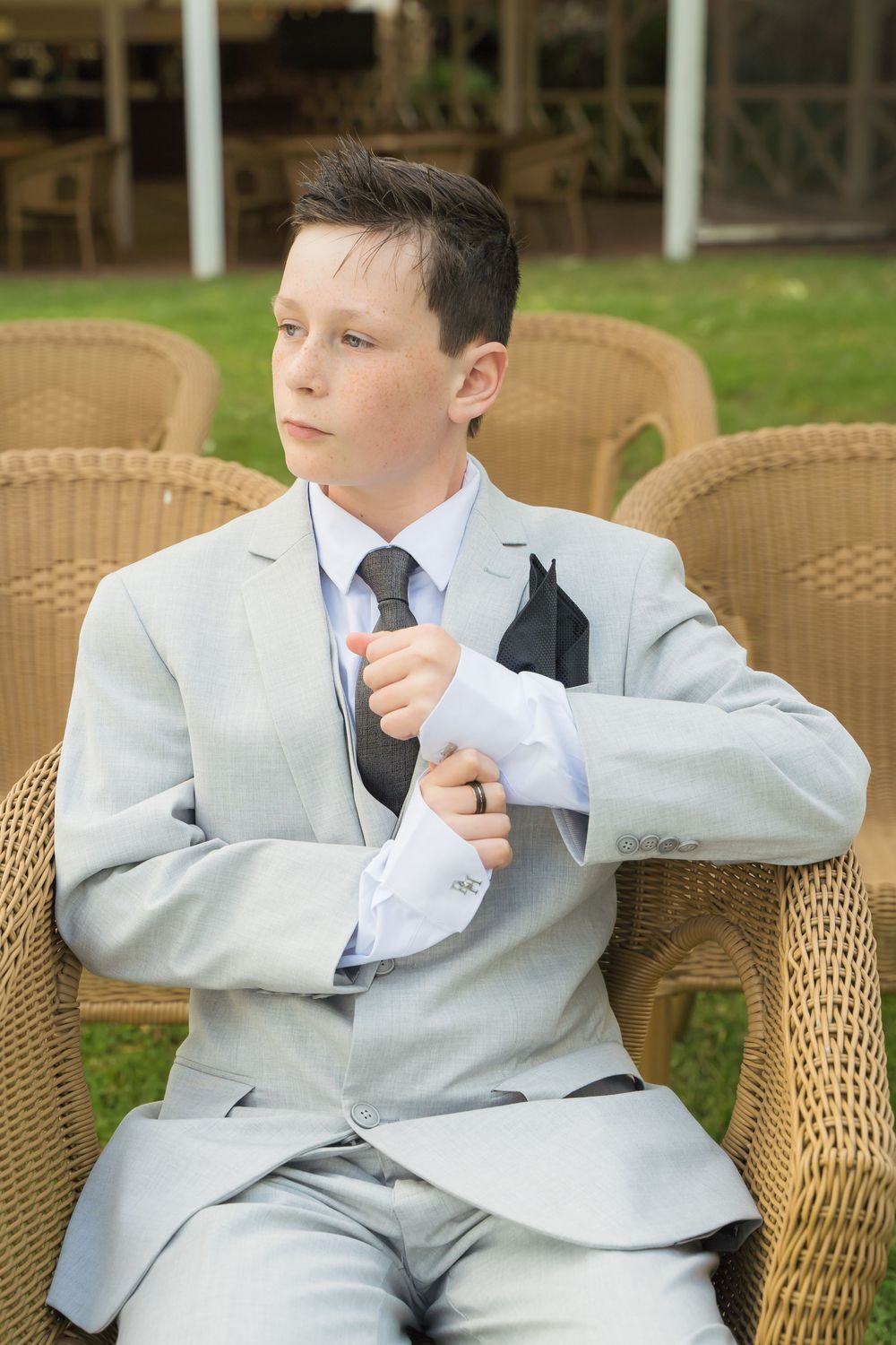 A series of photos showing someone in a light gray suit sitting on wicker furniture doing dance-like poses.
