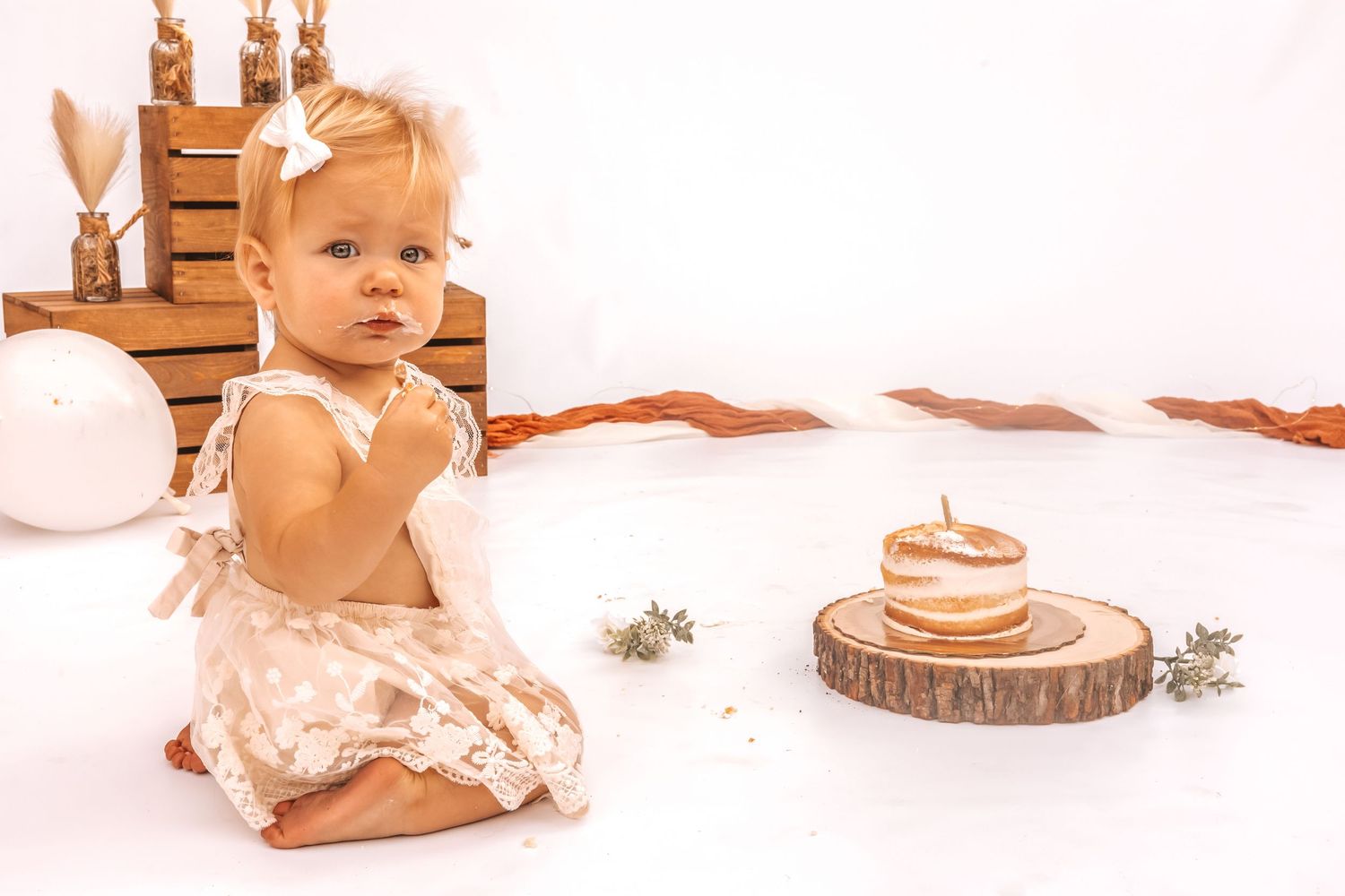 Baby milestone photo series on white background with rustic wood slice props.