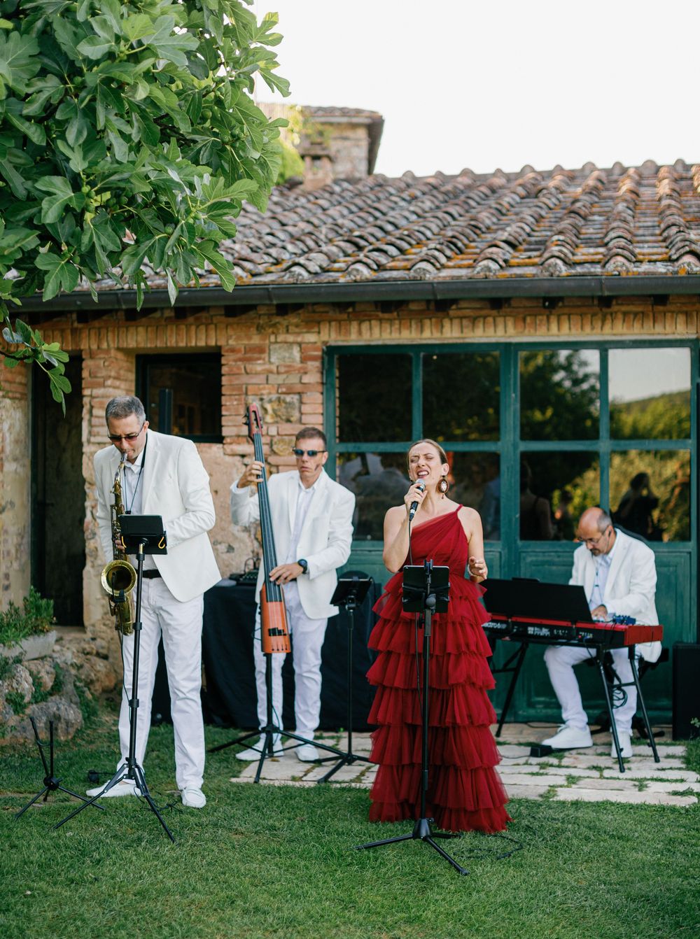 A sequence of outdoor dance photos showing performers in white outfits and flowing red dresses on a garden lawn.