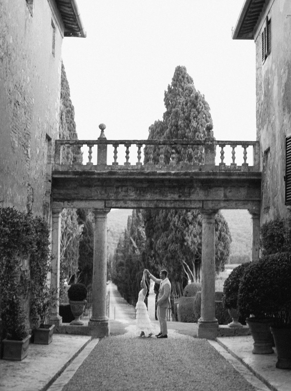 Sequence of black and white photographs showing a garden walkway with architectural columns and balustrades at Borgo Stomennano in Italy.