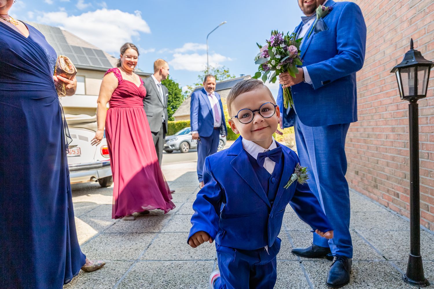 Three photos from a wedding celebration showing people in blue suits and pink dresses on a city street.