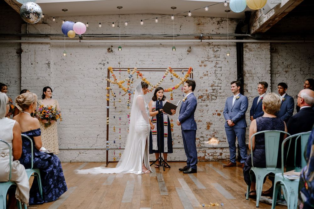 Industrial chic wedding venue features exposed brick walls, paper lanterns, and rustic decor for an intimate celebration.