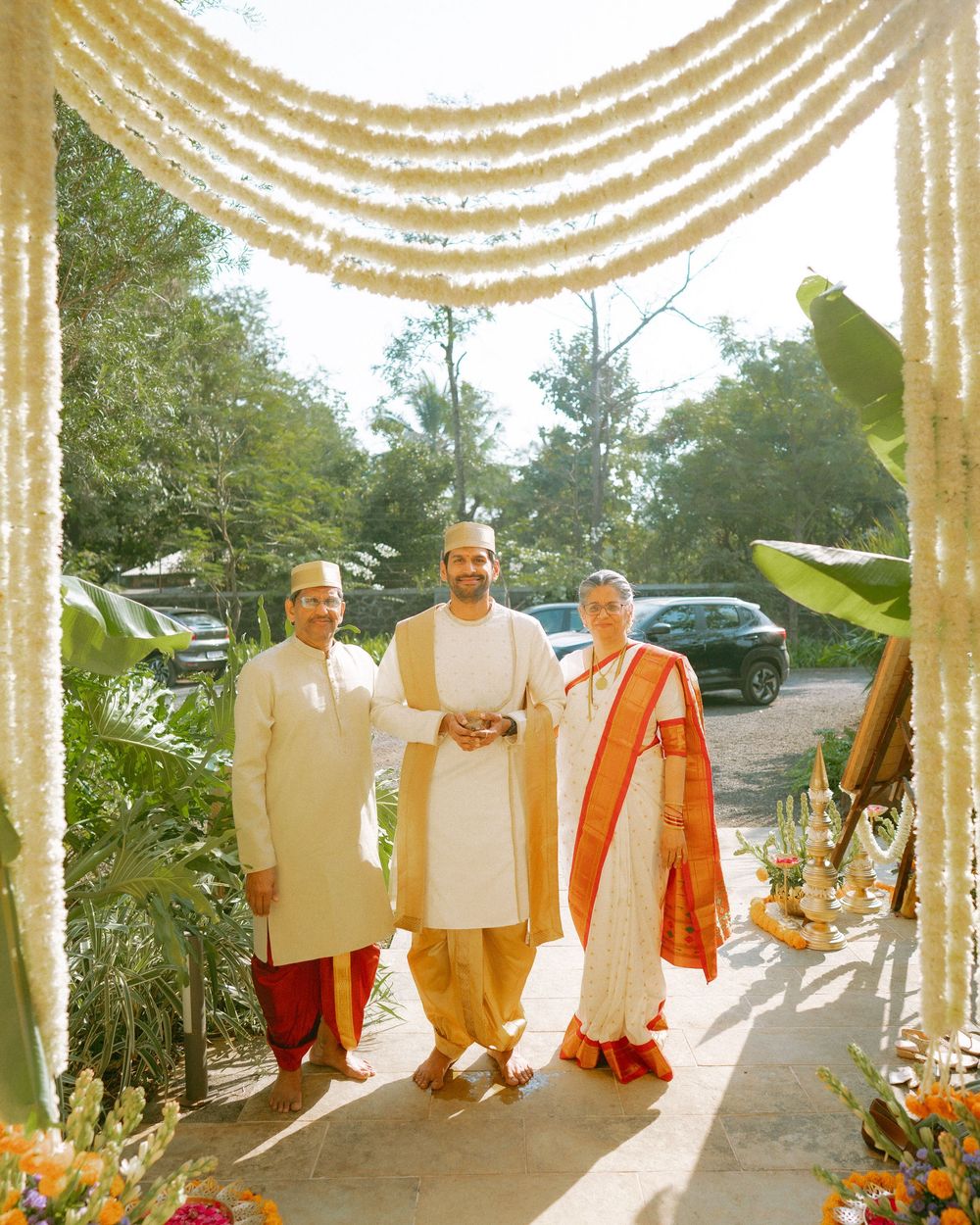 Group photo of people in traditional Indian attire under decorative floral ceiling arrangements.