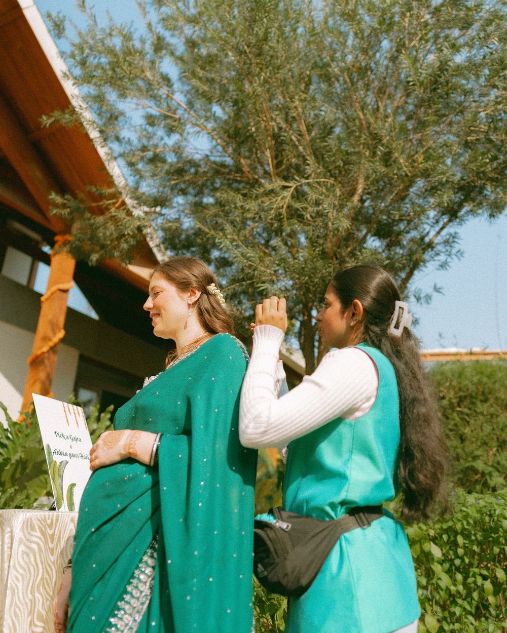 People in traditional Indian clothing standing together outdoors near a building.