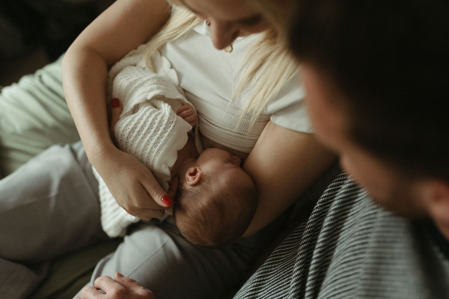 Intimate maternity photo session showing a couple embracing on a bed in soft natural light.